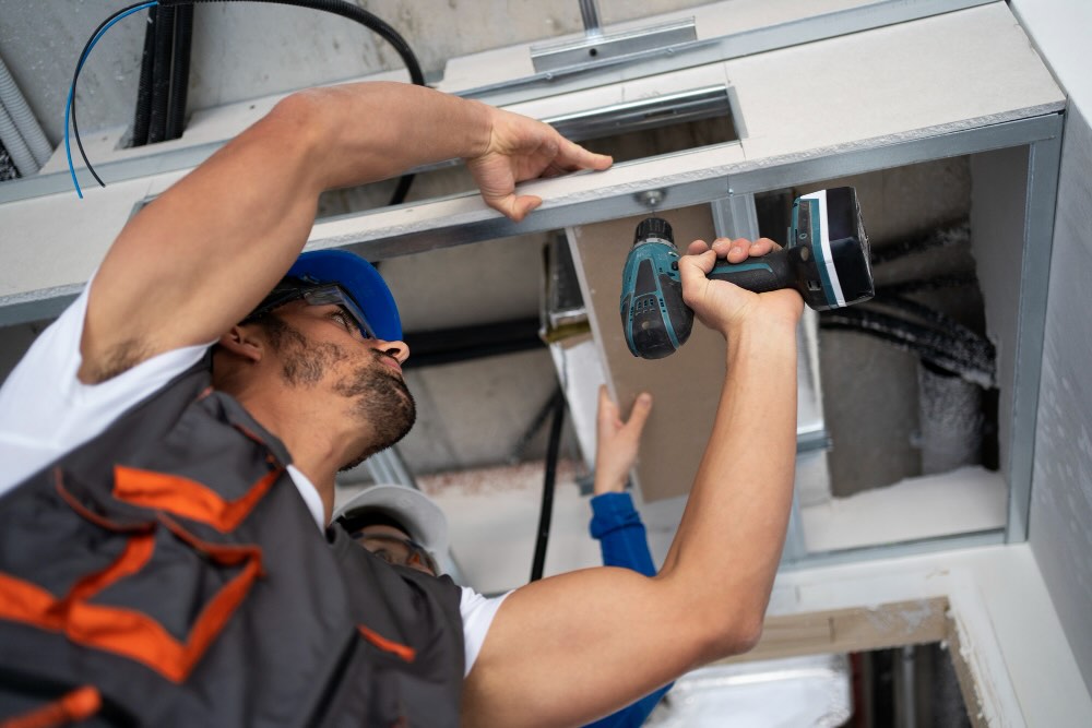 Maintenance technician working in a vacation rental Repairing a broken light during a maintenance task in a vacation rental